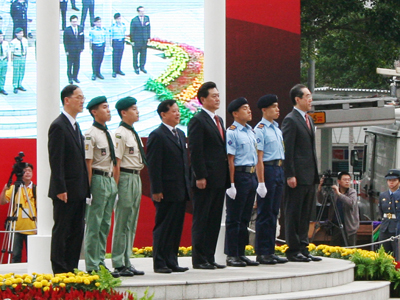 香港特區政府政務司司長唐年英先生(右一)，中聯辦副主任李剛先生(右四)，第三屆『中華民族文化周』團長、國家民族事務委員會副主任楊健強先生(左四)及特區民政事務局局長曾德成先生準備頒授「五四旗手」榮譽旗給來自香港民安隊少年隊和童軍總會的四位小升旗手。