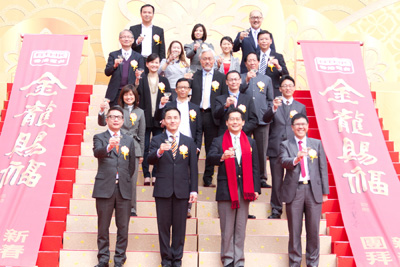 The guest of honour and various media representatives raising a toast on stage.